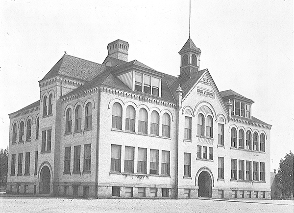 Cream-colored brick school with arched windows