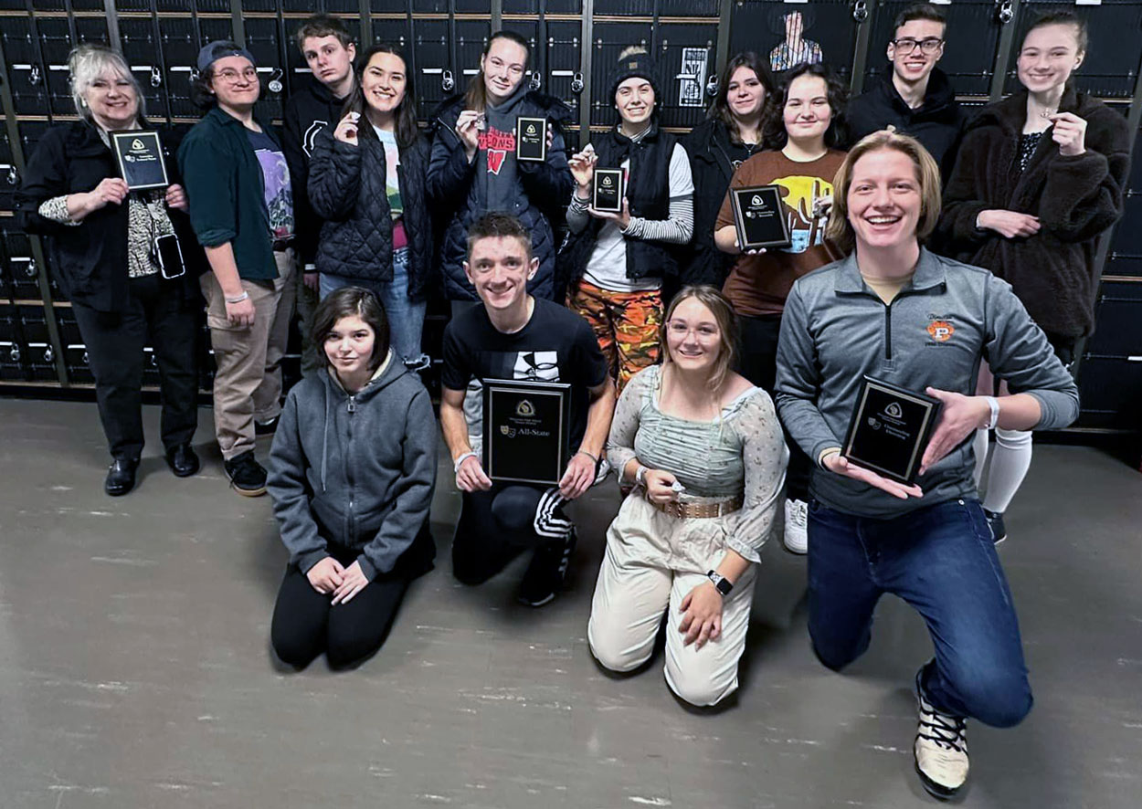 Group photo of cast and crew holding awards