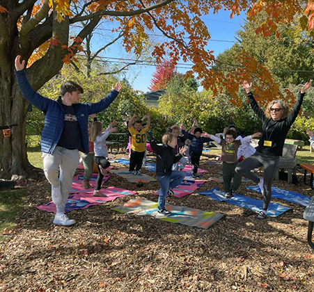 guests leading Fairview students in yoga outside