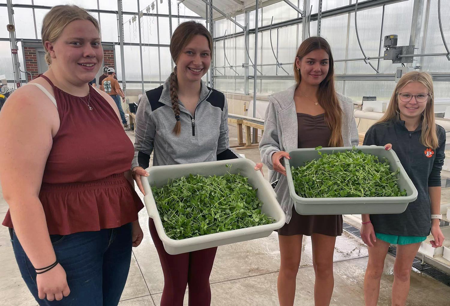 4 students with bins of shoots