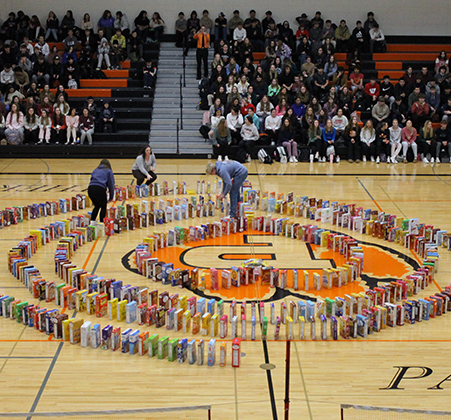 people lining up cereal boxes on gym floor
