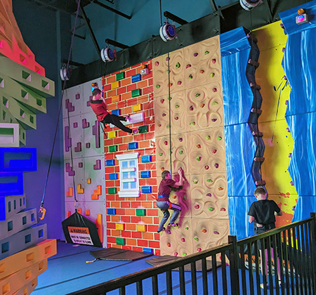 Riverview students climbing Urban Air rock wall