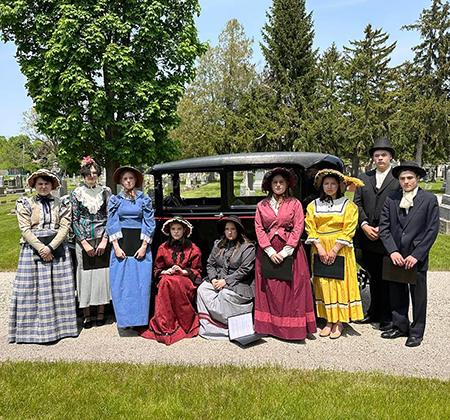 students in period dress with vintage car
