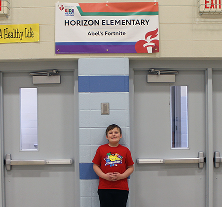 student under banner in gym