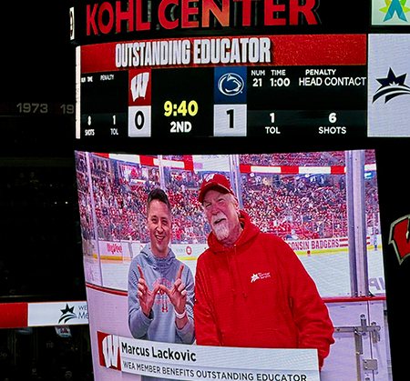 teacher with presenter on stadium screen