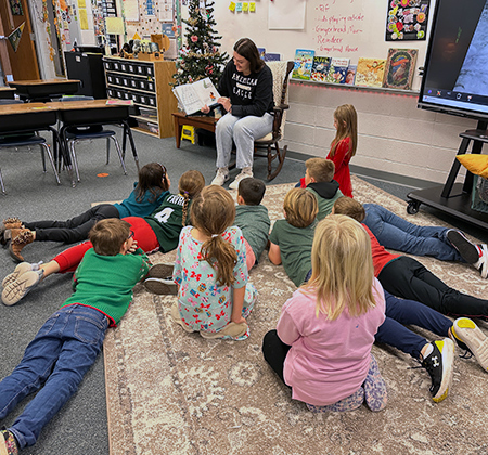 Team Panther member reading to students