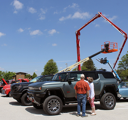 people looking at vehicles