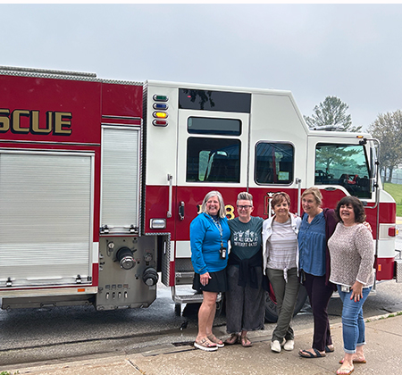 5 people in front of fire truck