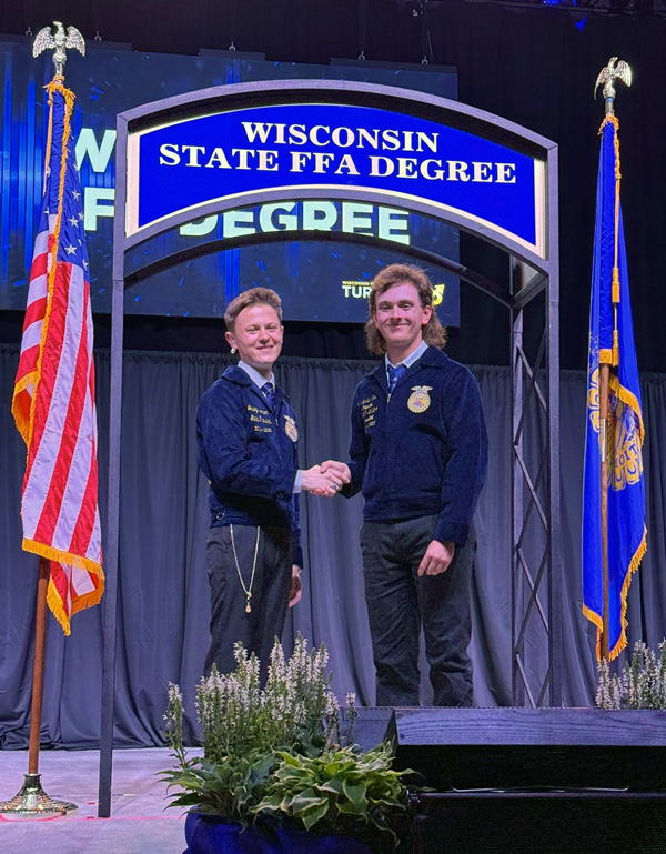 2 people on stage shaking hands