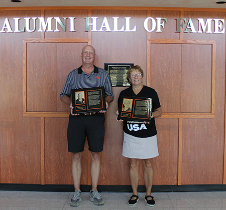 2 people holding plaques