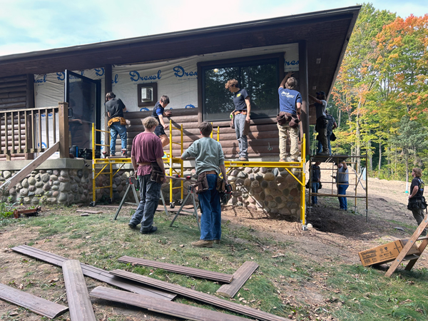 Students installing log siding