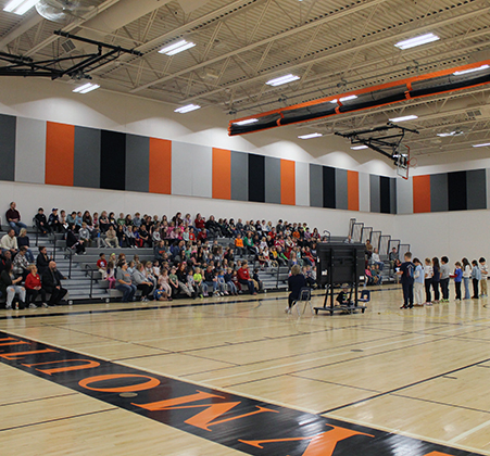 students speaking to audience in school gym