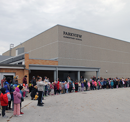 Bugler and students outside school