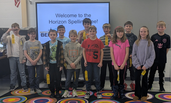 Horizon Spelling Bee participants holding yellow ribbons in the Horizon Library