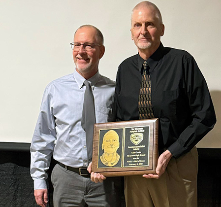 Coach Krzyzaniak with Coach Grahn, who is holding his plaque
