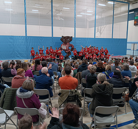 fourth-graders performing for students and families