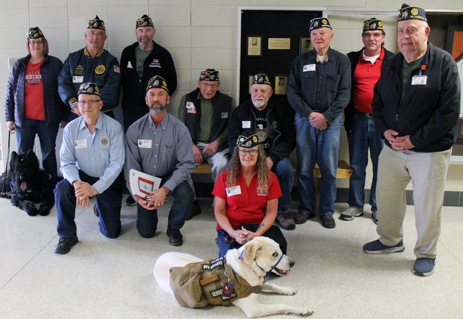 group photo of veterans around display case