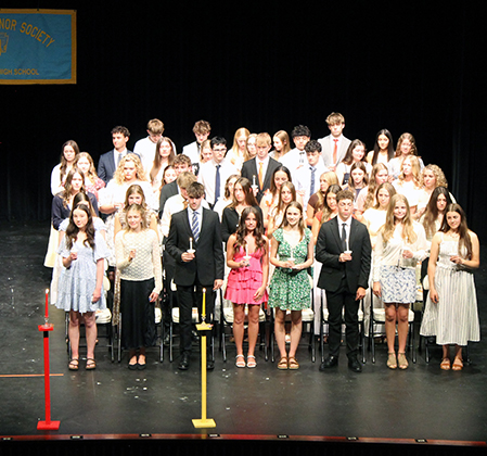 inductees on stage holding lit candles