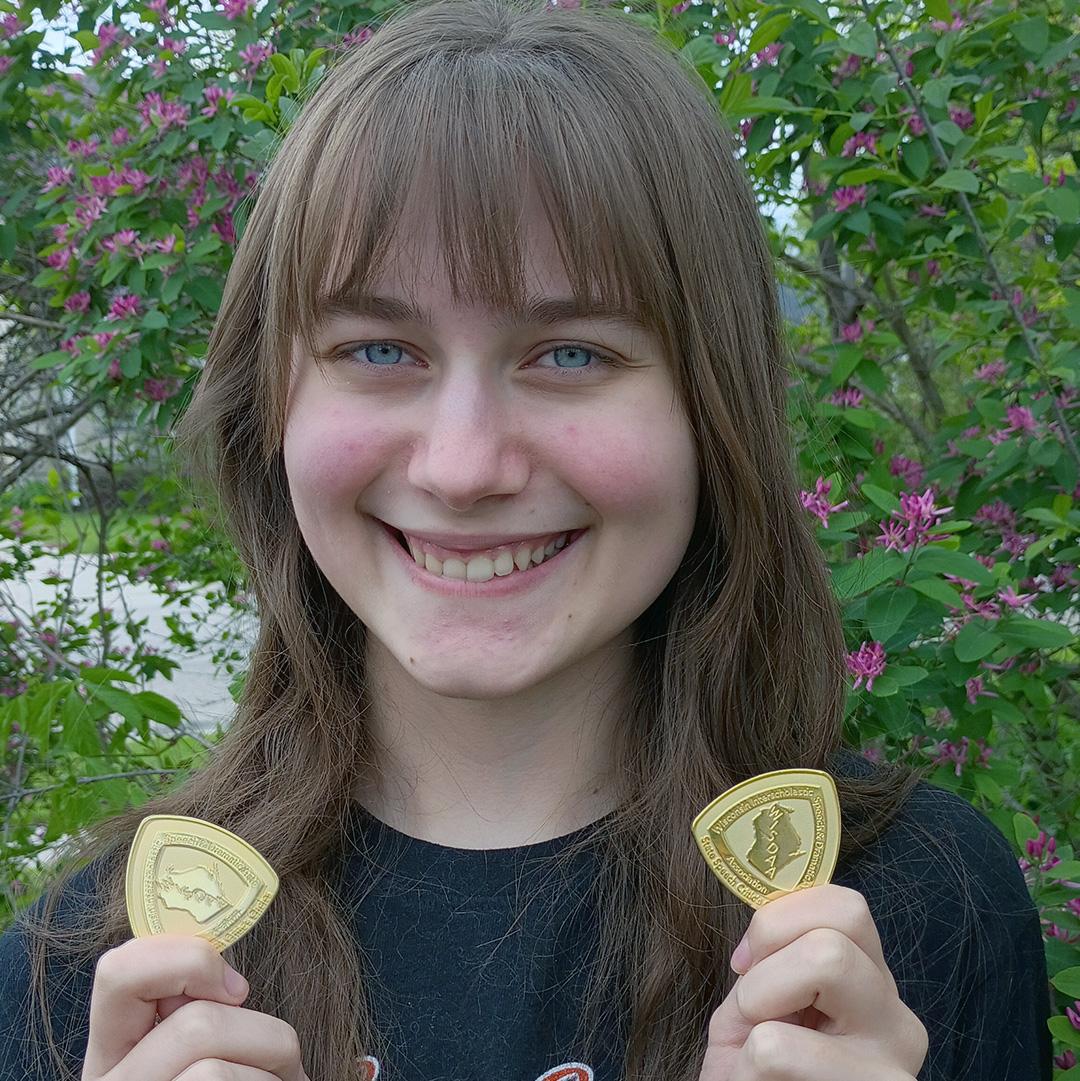 student holding medals