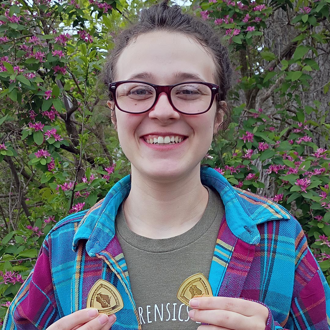 student holding medals