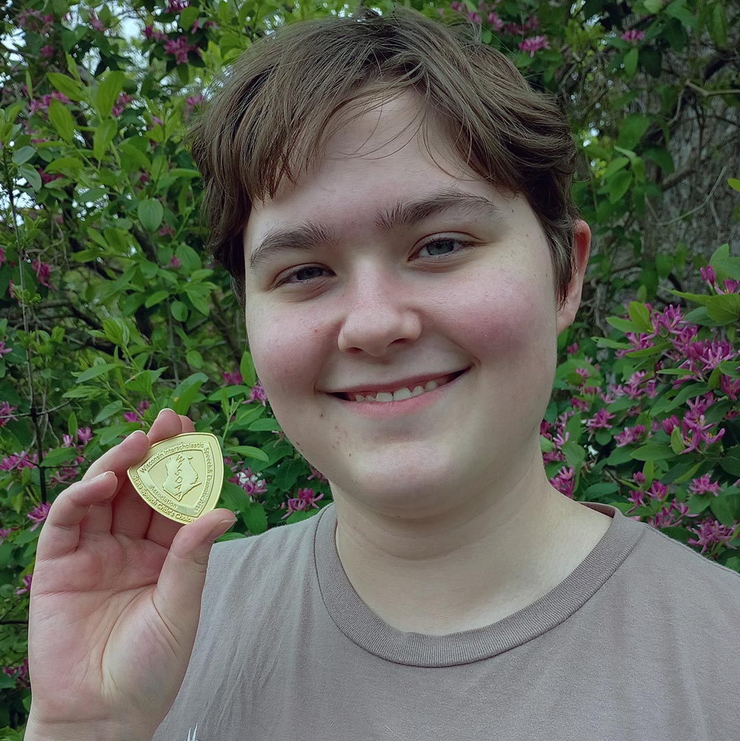 student holding medal
