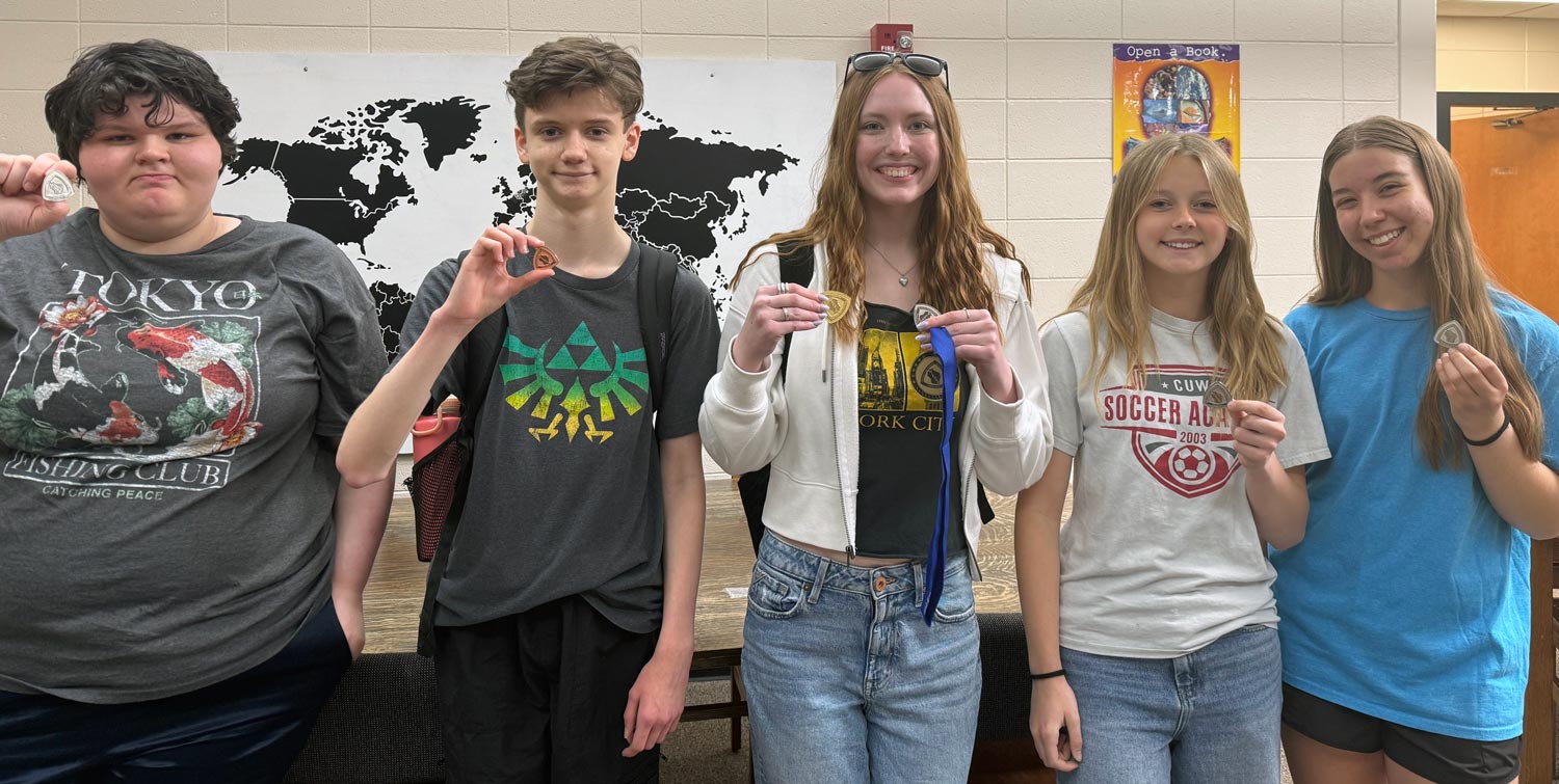 5 team members holding medals