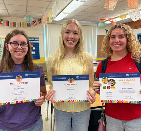 three students holding certificates
