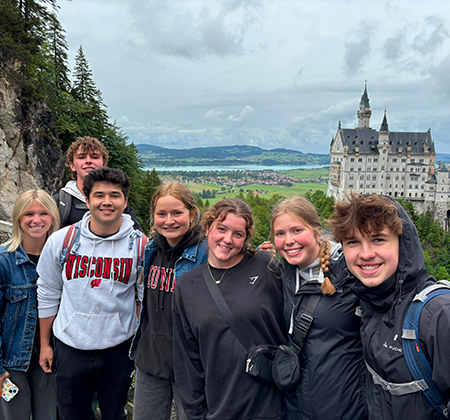 7 students with castle in background