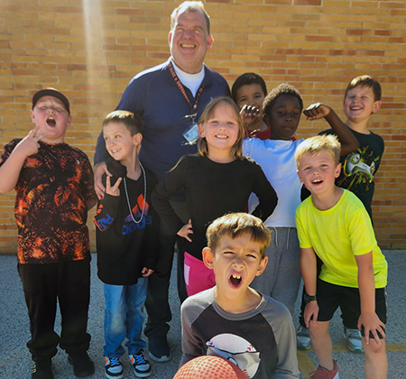 students with principal on playground