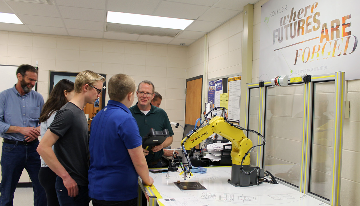 students and engineers working with robot