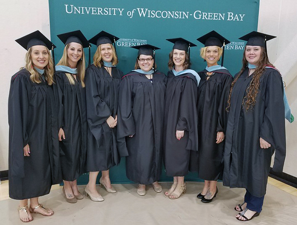 7 teachers in caps and gowns